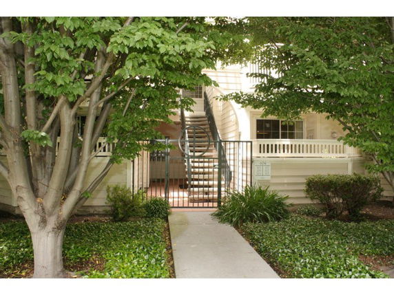 Front view of a building with stairs and a gated entrance.