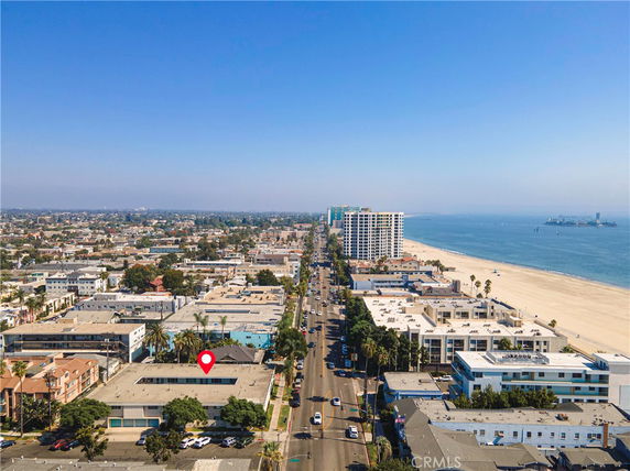 Panoramic view of a coastal cityscape with buildings and a beach.