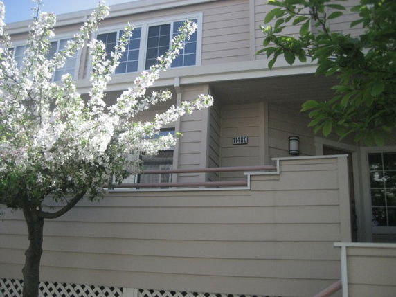 Front view of a two-story building with siding and a small balcony.