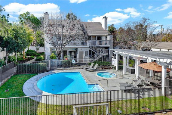 View of a house with a swimming pool and surrounding deck area.