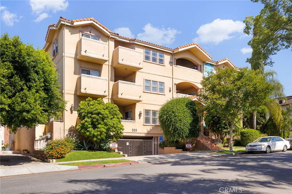 Front view of a multi-story apartment building with balconies.