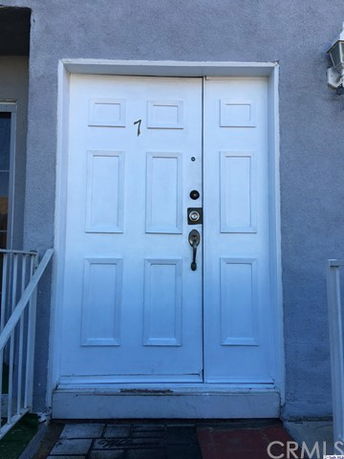 Front view of a white double door entrance with a number 7.
