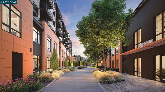View of modern apartment buildings with large windows and greenery along a pathway.