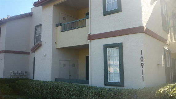 Front view of a two-story building with a balcony and green trim.