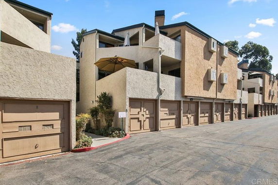 Front view of a multi-story apartment building with garage doors.