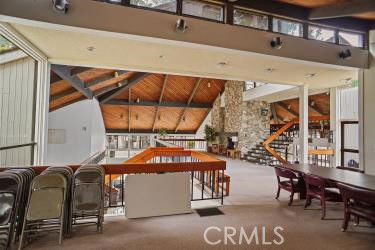 Interior view of a clubhouse with wooden ceilings, open spaces, and seating areas.