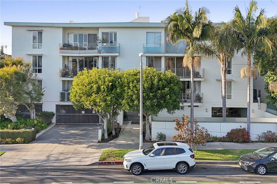 Front view of a multi-story apartment building with balconies.