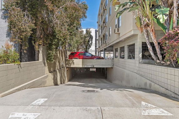 Entrance to an underground parking area beneath a multi-story building.