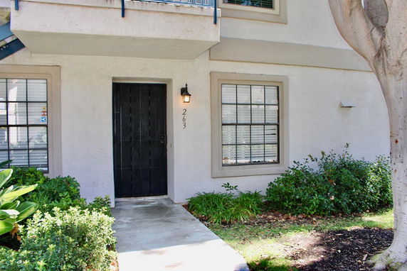 Front view of a house with a black door and two windows.