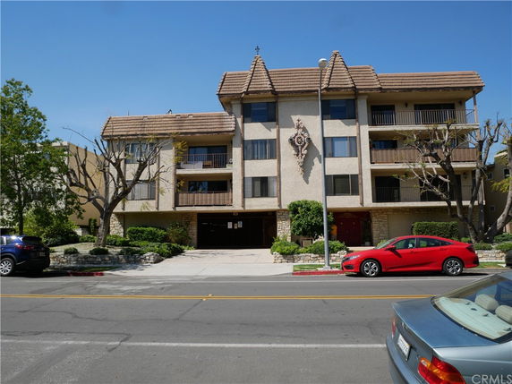 Front view of a multi-story building with balconies and decorative elements.