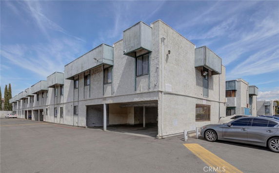 Front view of a multi-story building with a parking area.