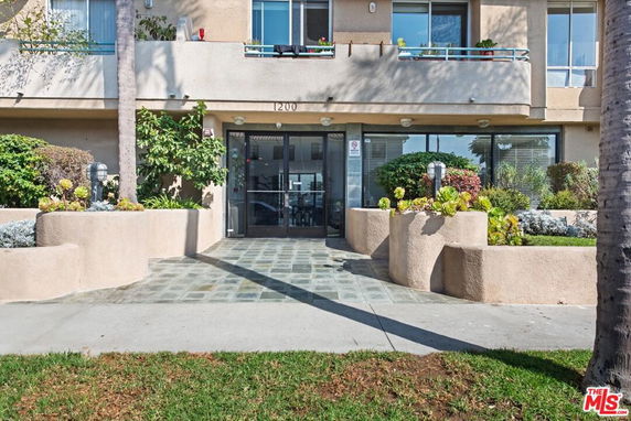 Front view of a building with glass doors and decorative planters.