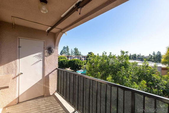 View of surrounding trees and buildings from an outdoor balcony.