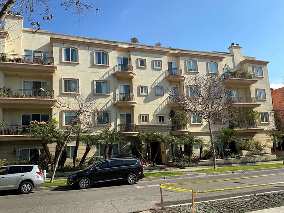 Front view of a four-story residential building with balconies.