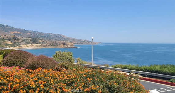 Panoramic view of a coastal landscape with ocean and cliffs.