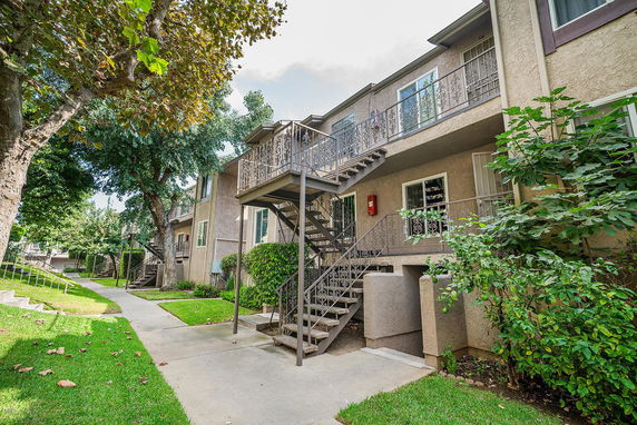 Front view of a multi-story apartment building with exterior staircases and balconies.