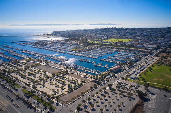 Aerial view of a coastal city with a large marina filled with boats and extensive parking areas.