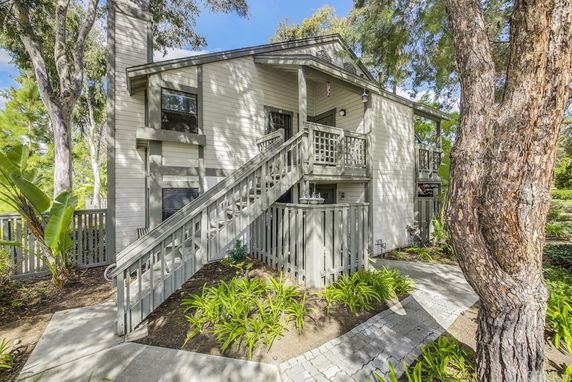 Front view of a two-story house with an external staircase and railing.