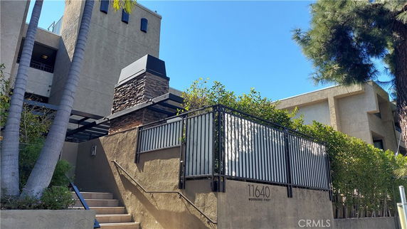 Front view of a multi-story building with a staircase and outdoor entrance.