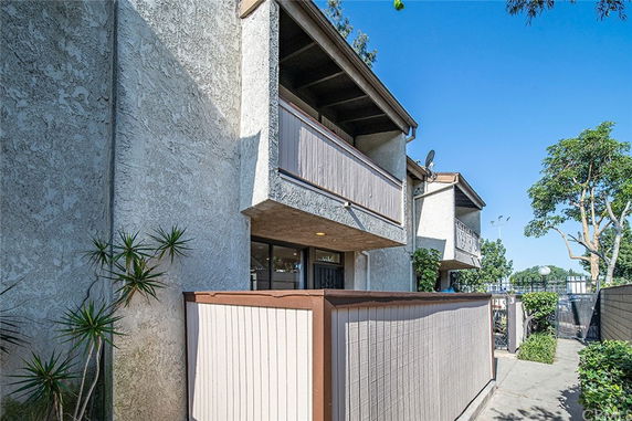 Front view of a multi-story building with balconies and stucco exterior.