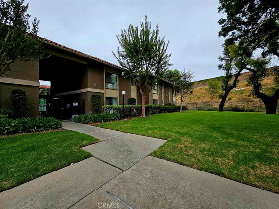 Front view of a two-story building with a central entrance and grassy surroundings.