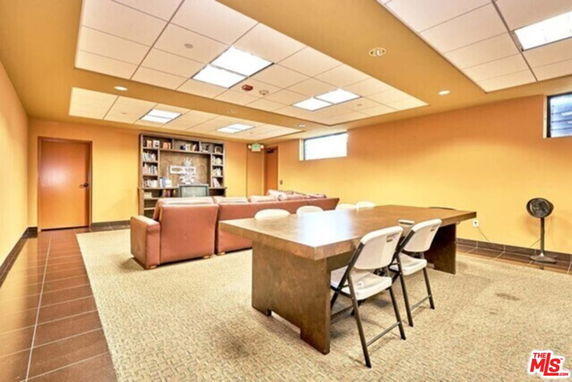 Common area with a table, chairs, couches, and a bookshelf.