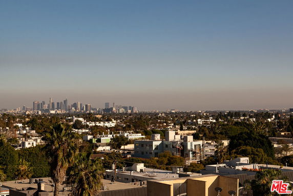 Wide-angle view of a cityscape with numerous buildings and a clear sky.