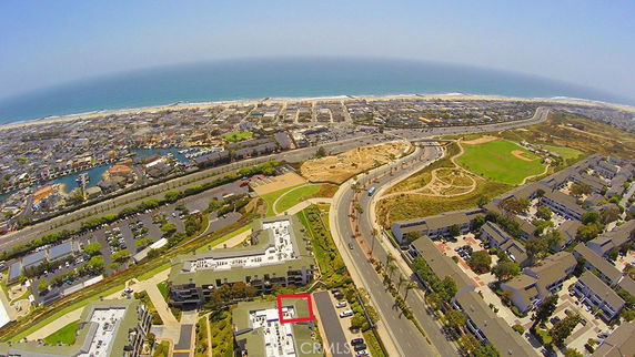 Wide angle aerial view of coastal area with roads, buildings, and the ocean in the background.