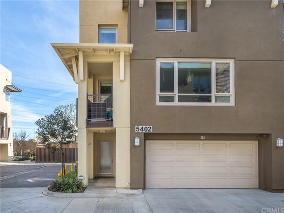 Front view of a modern multi-story townhouse with a garage.