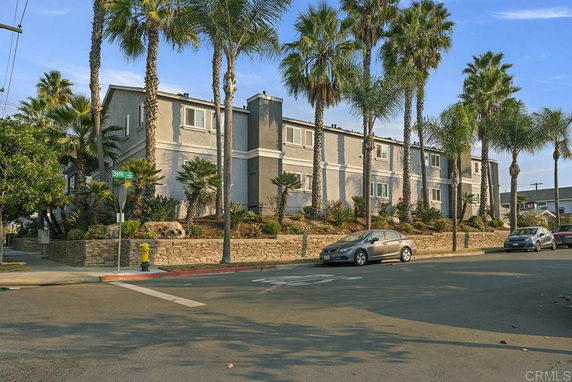 Front view of a two-story building with palm trees.