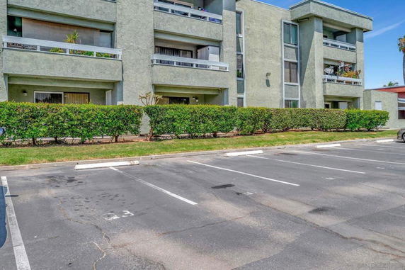 Outdoor parking area in front of a multi-story apartment building.