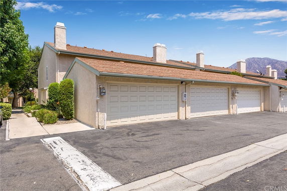 Front view of a building with multiple garages and a sloped roof.