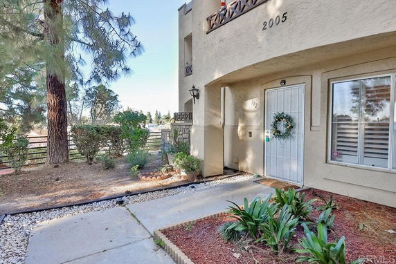 Front view of a building entrance with a wreath on the door and landscaped area.