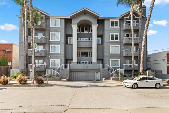 Front view of a four-story apartment building with balconies.