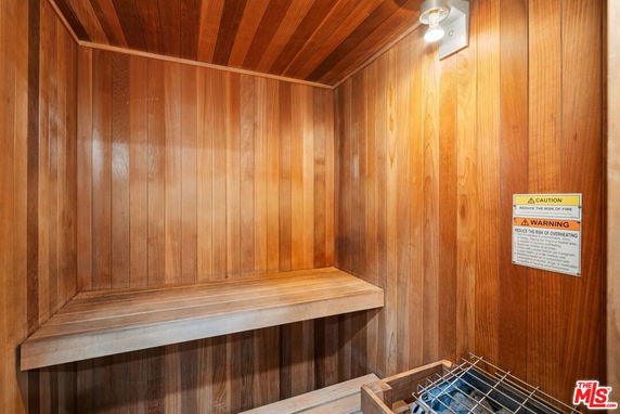 Interior of a wooden sauna room with a light fixture and heating element.