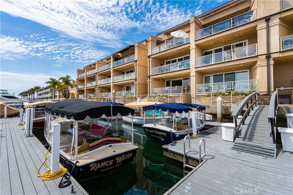 Front view of a multi-story waterfront building with balconies.