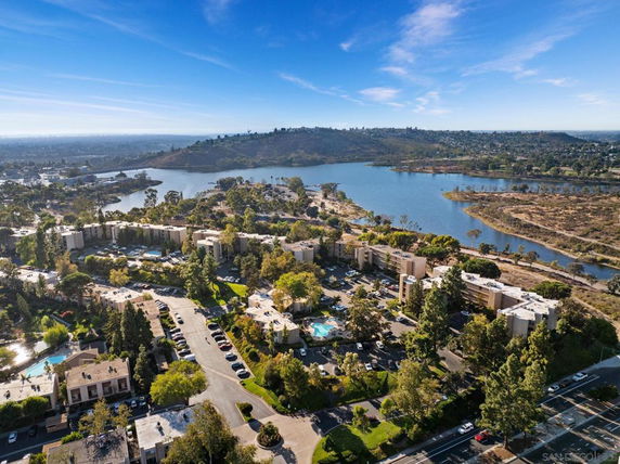 Wide-angle view of residential buildings and surrounding landscape with a lake.