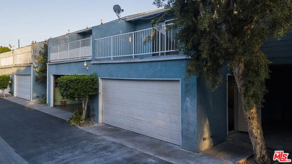 Front view of a two-story building with garages and balconies.
