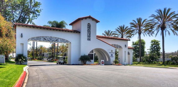 Front view of a gated entrance with arches and tiled roof.