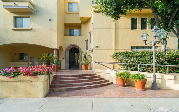 Front view of a multi-story building with an entrance and steps.