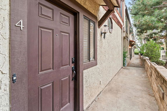 Exterior view of a building entrance with a brown door numbered 4.