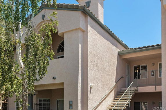 Front view of a multi-story building with an exterior staircase.