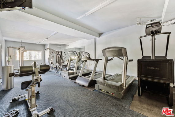 Indoor gym area with exercise equipment including treadmills and weight machines.