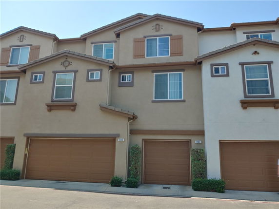 Front view of a multi-story residential building with garage doors.