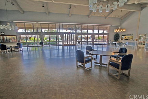 Spacious indoor recreational area with tables, chairs, and large windows.