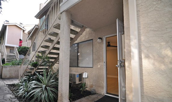 Front view of a two-story residential building with exterior stairs.
