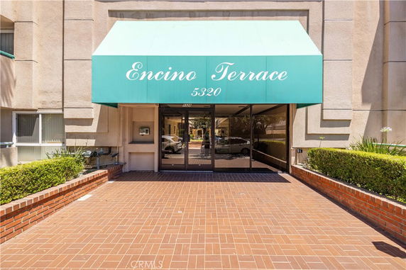 Entrance view of a building with a green canopy labeled 'Encino Terrace'.