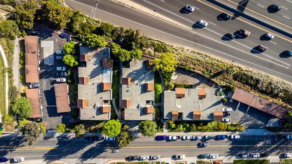 Aerial view of a residential complex with several buildings located near a highway.