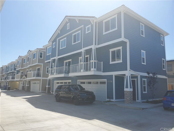 Front view of a multi-story house with a garage and balconies.