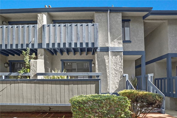 Front view of a two-story building with balconies and a small porch area.